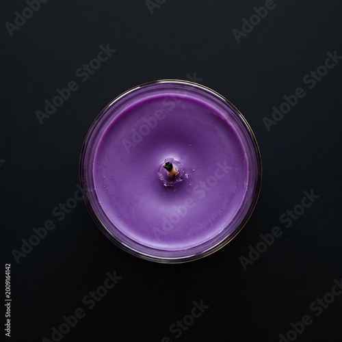 Violet candle without flame centered on dark background