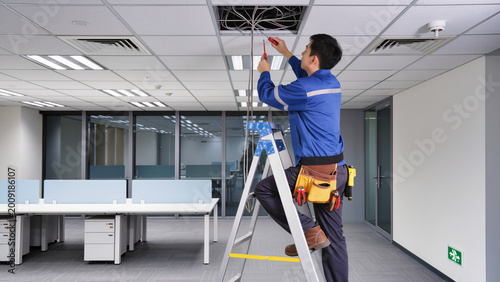Obraz na płótnie Technician repairing wires in office ceiling