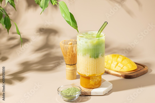 Iced mango matcha latte in glass on the table