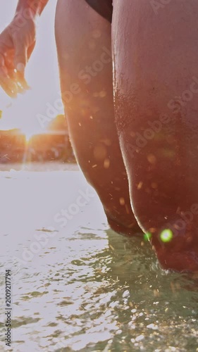 Vertical video. Low Angle View Of Woman In Sea As Wave Covers Body In Slow Motion With Sunlight And Splashing Water, Dynamic Summer Beach Scene