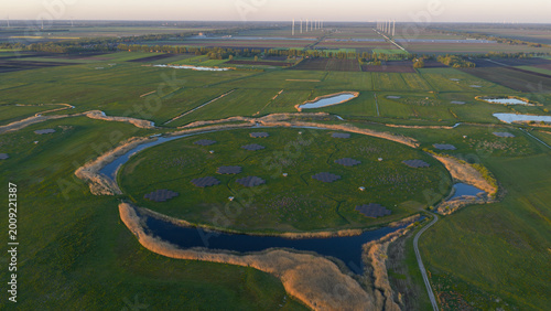 Aerial view of the LOFAR superterp radio telescope station featuring a circular island with antenna arrays surrounded by water and green fields in Buinen, Drenthe, Netherlands.