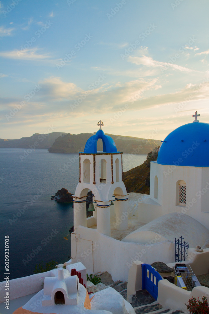 Obraz premium traditional greek village Oia of Santorini, with blue domes of churches at sunset, Greece, retro toned