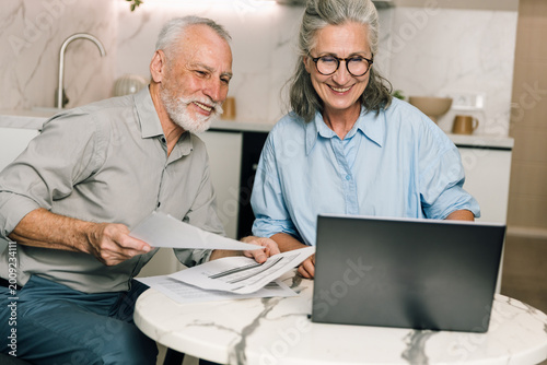 Couple discusses family budget and bills while using laptop at home