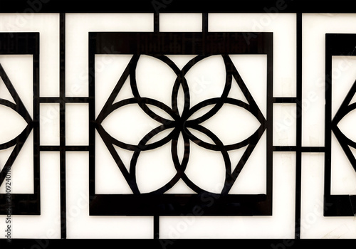 Konstfotografi Close up of black acrylic laser cut in geometrical rectangle and flower shape pattern, isolated in white background