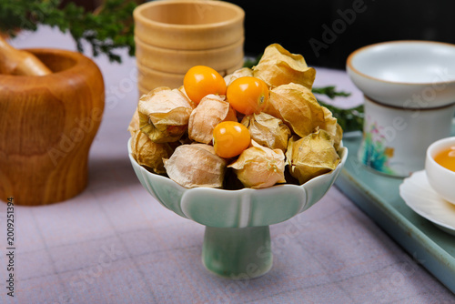 Quadro su tela Fresh cape gooseberries in husks in ceramic bowl on rustic table