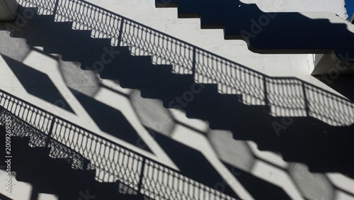 Shadows and Patterns of Staircase Railings and Steps in Sunlight
