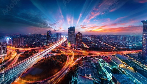 aerial view of a city skyline at night with illuminated buildings and light streaks from traffic creating a dynamic and vibrant urban scene with a dramatic sky and scattered lights for travel