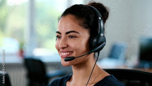 Young woman smiles warmly while wearing headset