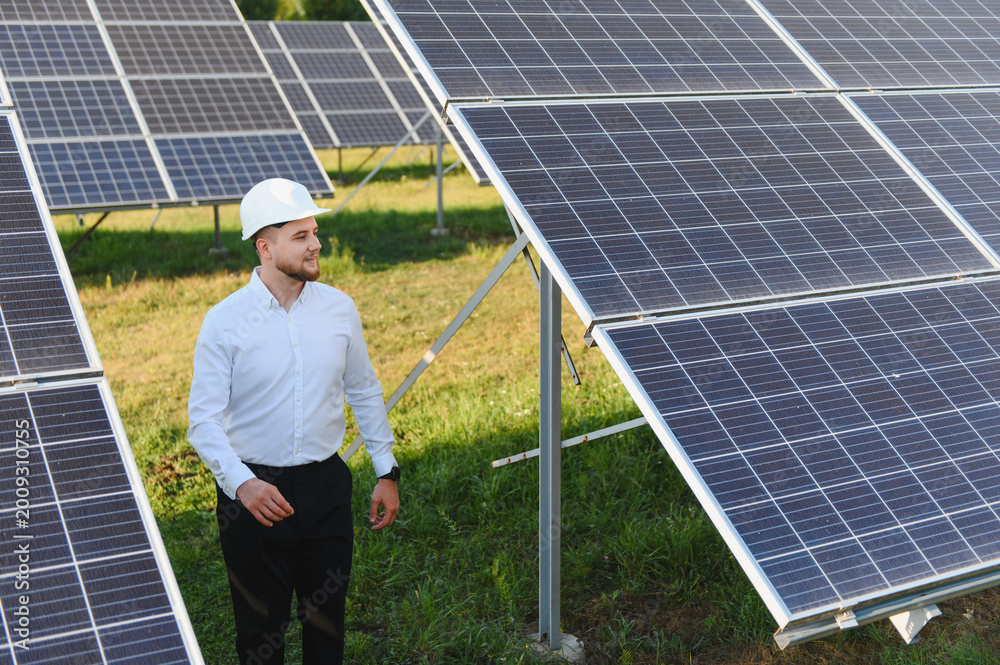 Fototapeta premium Engineer inspecting solar panels at photovoltaic power plant
