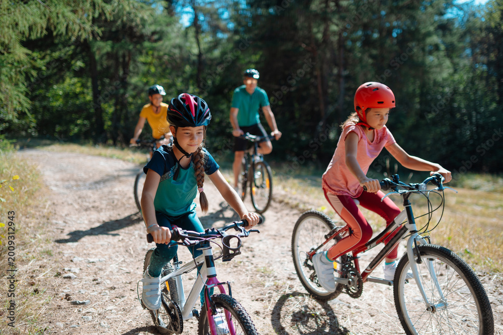 Fototapeta premium Active family enjoying biking adventure in scenic landscape.