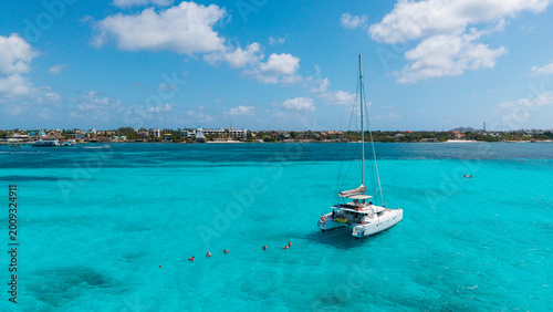 Canvas Print Catamaran Anchored with Snorkelers on Turquoise Caribbean Sea with Dramatic Clou