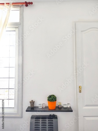 white wall background with copy space next to a window and a few decor colorful items