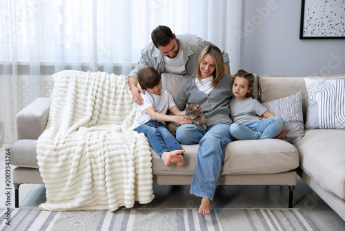 Konstfotografi Happy family with their cute cat at home. Adorable pet