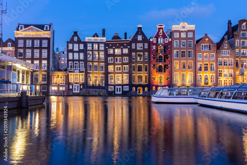 Amsterdam architecture on Damrak canal at night, Netherlands