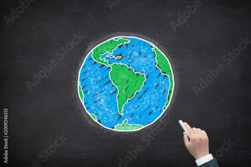Planet Earth. Hand drawing a chalk globe on a blackboard.