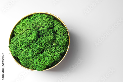Foto Green preserved moss in bowl on white background, top view