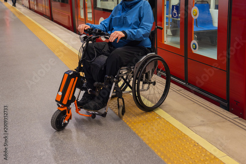 Person with disability on wheelchair using metro station for accessible transport.