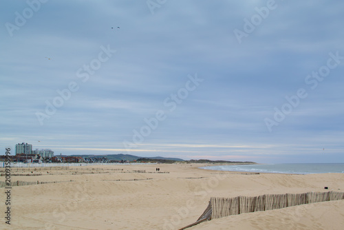 Calais beach in northern France, promenade near the sea, coastline, sand, dunes, France, La Manche, people walking far away, a large beach