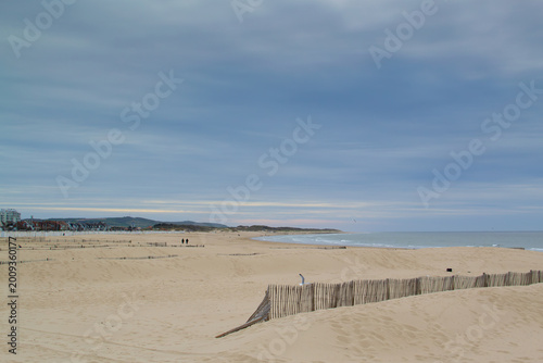 Calais beach in northern France, promenade near the sea, coastline, sand, dunes, France, La Manche, people walking far away, a large beach
