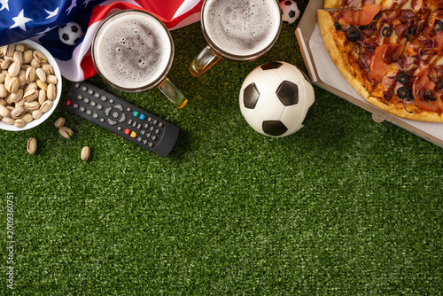 Fotografija Football championship watch party at home with pizza, beer, pistachio, remote an