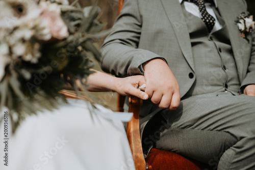 Quadro su tela Les mains jointes d'un couple de mariés assis lors de leur cérémonie