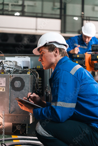 Quadro su tela Repair specialist inspects machinery in factory ensuring industry standards with