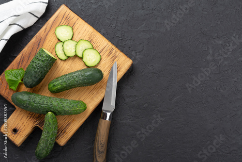 Cucumbers with leaves on concrete background,top view
