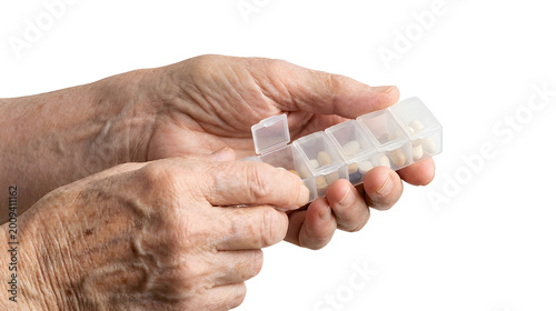 Elderly hands holding medication organizer, symbolizing routine care and chronic treatment. Minimal and realistic healthcare concept for aging and medical use, Isolated on White background