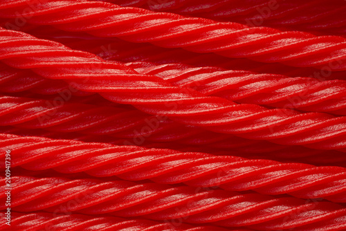 A top down view of a pile of red licorice sticks, as a background.