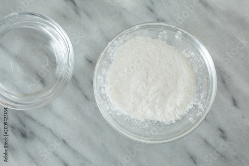 Foto A top down view of a glass condiment cup of the ingredients for a corn starch slurry