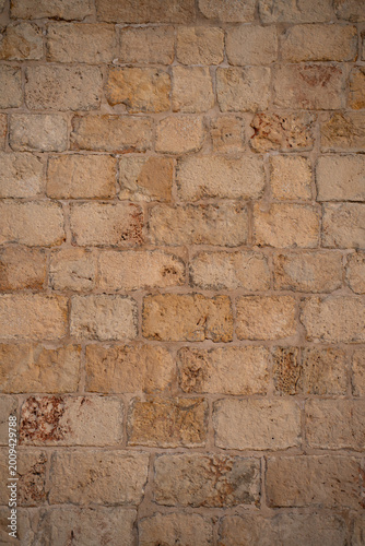 Vertical background of a traditional Maltese limestone wall. Authentic yellow stone masonry texture in Malta.