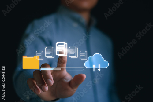 Businessman using digital cloud storage interface for secure access, online file transfer and document management system. Data backup technology concept with virtual cloud computing. Cybersecurity.