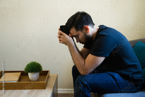 Fotografie Profile view of depressed young man suffering from anxiety and mental health pro