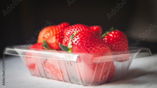 Foto Strawberries in plastic box on white background. Healthy food.