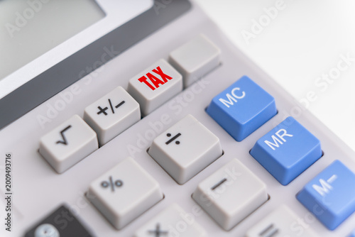 Tax button on calculator keypad close up for finance and accounting concept