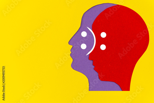 Abstract overlapping human head silhouettes with emotional duality icon,