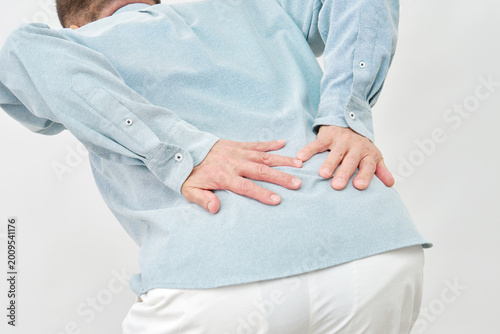 Foto 白背景で腰を押さえる男性　顔無し