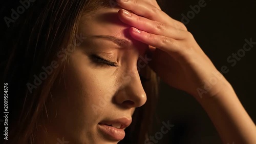 Woman suffering from a headache holding her forehead in pain.