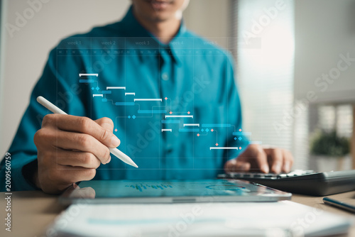 Professional using tablet and calculator with Gantt chart interface for project scheduling, task management and workflow planning, representing deadlines, milestones and business productivity.