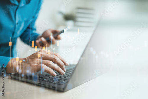 Fotografie Investor using laptop with candlestick chart interface, representing stock market analysis, financial trading, investment risk assessment, market trends, portfolio strategy and digital finance