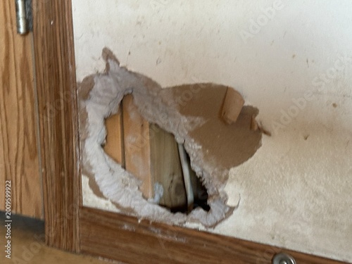 Hole in residential interior wall showing home maintenance and repair concept