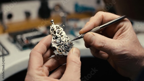 Watchmaker hands adjusting movement with precision on workbench