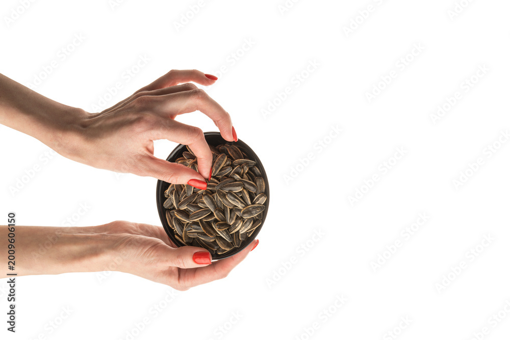 Fototapeta premium Female hand sunflower seeds on a white background isolation