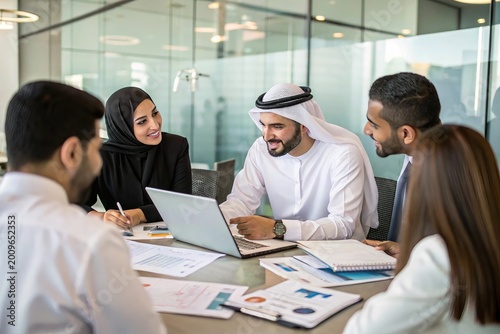 Five professionals gather around a table in a modern office