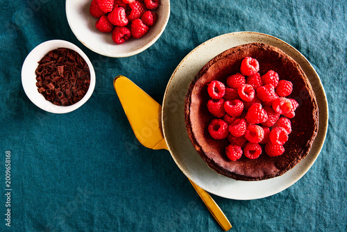 Chocolate Basque Cheesecake with Raspberries and Chocolate on Blue Linen Tablecloth Horizontal Shot