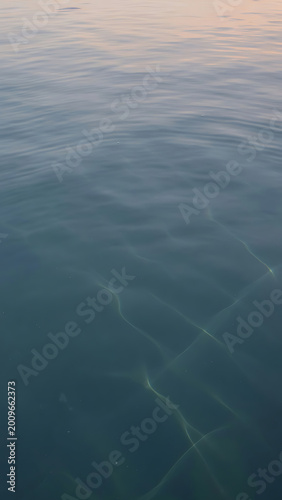 Calm Blue Water Surface Reflecting Soft Pink Sky Light Gentle Ripples Create Patterns