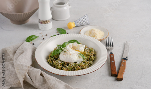Fotografía Buckwheat porridge with spinach pesto and poached eggs served on light table