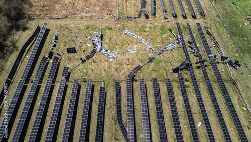 Aerial wide shoot of a solar energy field destroyed by a tornado with broken panels scattered across the ground.