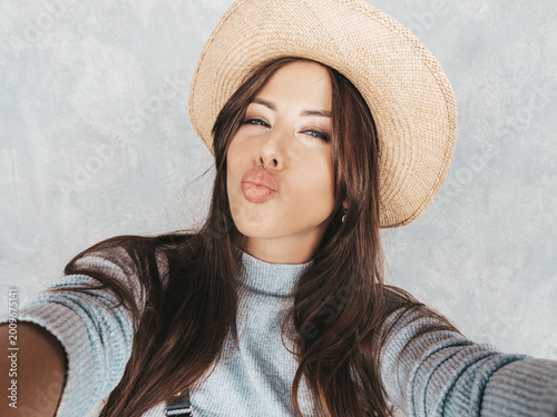 Konstfotografi Portrait of cheerful young woman taking photo selfie and wearing modern clothes and hat