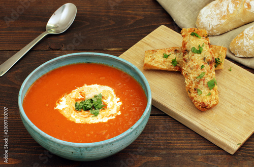 bowl of homemade tomato soup served with cheese baguette
